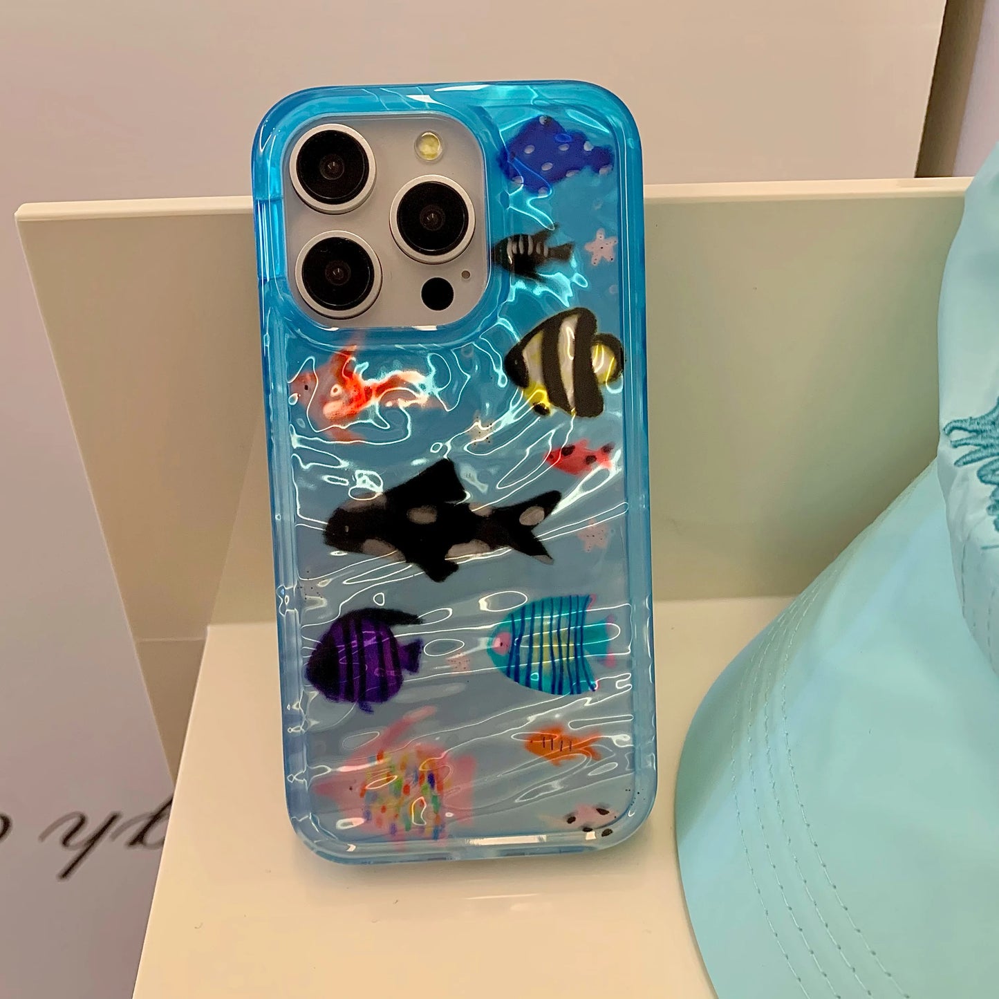 Korean-inspired ripple texture phone case featuring adorable aquatic fish design. Stylish and protective, it safeguards your iPhone from scratches while adding a cute, playful look.