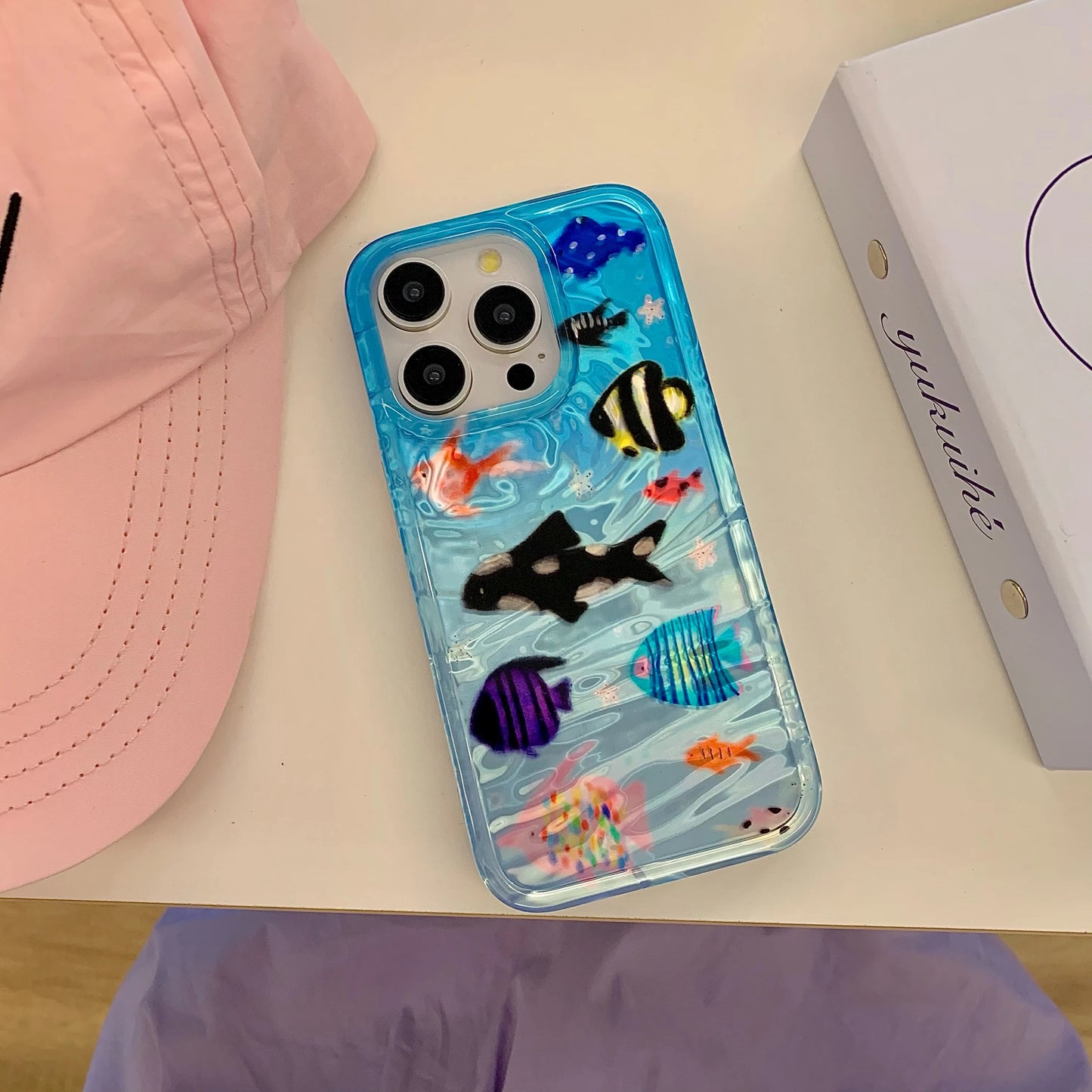 Korean-inspired ripple texture phone case featuring adorable aquatic fish design. Stylish and protective, it safeguards your iPhone from scratches while adding a cute, playful look.